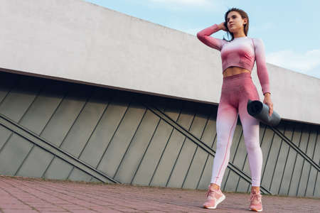 Athletic woman holding yoga mat in handの写真素材