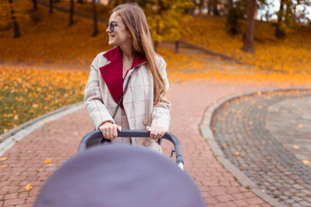 Happiness mother with baby stroller is walking