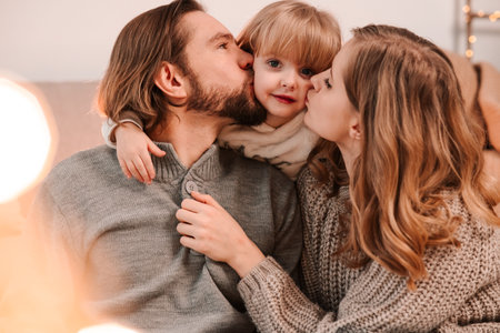 Happy parents kiss little daughterの写真素材