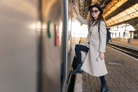 Girl enters to the train car. Traveler at the train stationの写真素材