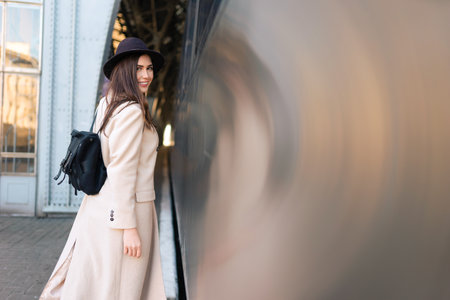 Beautiful traveler with backpack on the platform of the railway station. Young woman near trainの写真素材