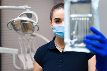 Female dentist doctor holds sterilized instrumentsの写真素材
