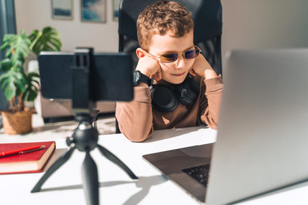 Schoolboy watches online video lessons on laptop. Studying during an epidemic