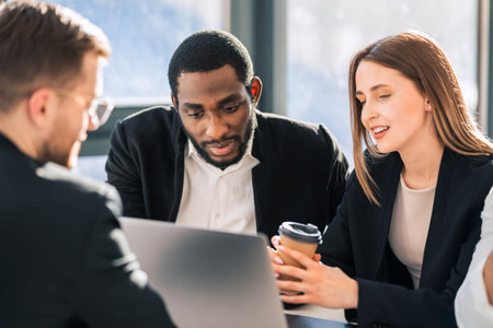 Multiracial office workers behind a laptop