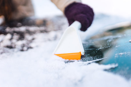 Cleaning car glass from ice with a scraper