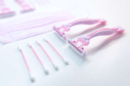 Set of disposable pink female razors, ear sticks and medical maskの写真素材