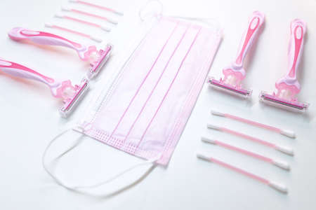 Set of disposable pink female razors, ear sticks and medical maskの写真素材
