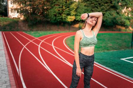 Tired runner wipes her face with her hand