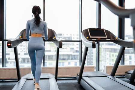 Back view of a athletic woman on a treadmillの写真素材