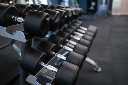 Rows of dumbbells on a rack in a gymの写真素材