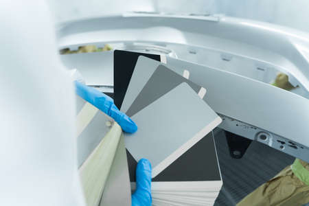 Car painter holding samples of car paint shades. car body color selectionの写真素材