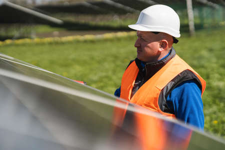 Man inspecting panels at a solar power plantの写真素材