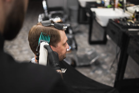 Close up view of b barber master cutting male client with clipper