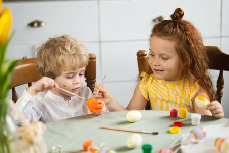 Little children are passionate about coloring Easter eggsの写真素材