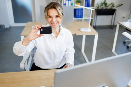 Smiling business woman showing credit card