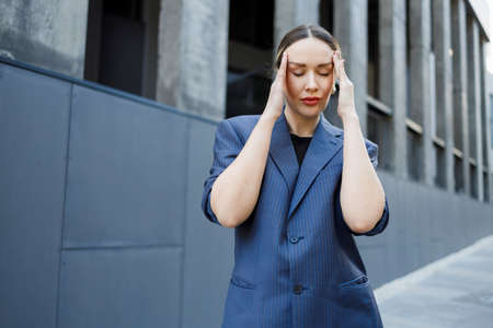 Stressed business woman having headache from overworkedの写真素材