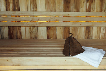 Bath hat and white towel on wooden boards in the saunaの写真素材