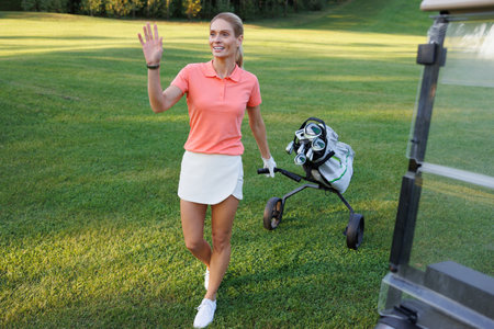 Blonde Golfer on Course Carrying Bag of Golf Clubsの写真素材