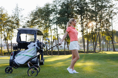 Athletic Blonde Female Golfer on Green with Club Setの写真素材