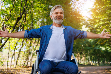 Grasping Serenity: Disabled Man in Wheelchair at Parkの写真素材