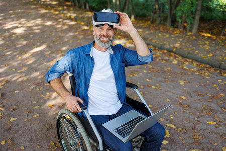 Digital Mobility: Wheelchair-Bound Person Exploring Augmented Reality in Parkの写真素材