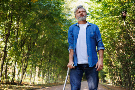 Graceful Encounter: A Crutch-Aided Walk in Natureの写真素材
