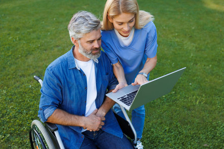 Outdoor Health Consultation: Nurse Providing Support to Wheelchair Userの写真素材