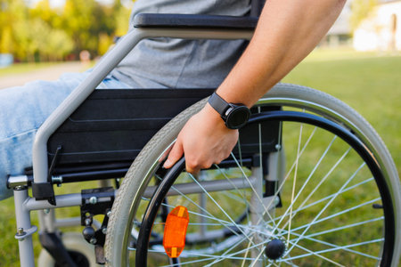 Outdoor Accessibility: Focus on Hand of Young Man in Wheelchair