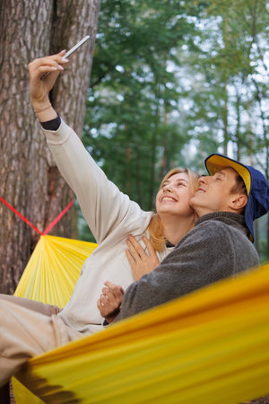 Young Couple Relaxing and Smiling Together in a Nature Hammock