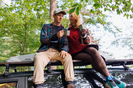 Couple Enjoys Tea on Top of a Travel Van
