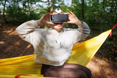Blissful Moments: Girl with VR Glasses Relaxing in Nature's Embrace