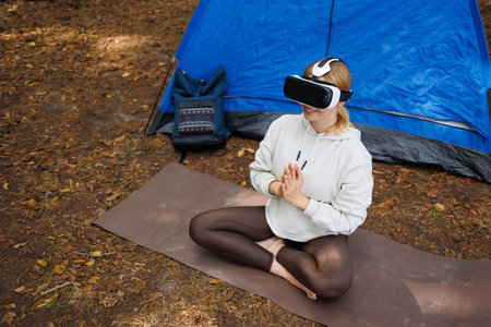 Sporty Young Explorer Engaging with VR Technology in the Woodsの写真素材