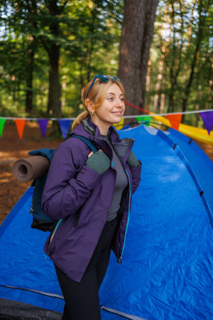 Woman tourist with a backpack in the forest near the tentの写真素材