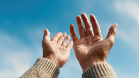 Hands Raised Toward Blue Sky in Prayer or Hopeの素材