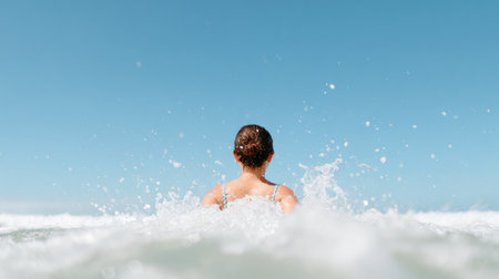 Woman Entering Ocean Waves from Behindの素材