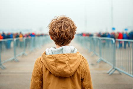 Child watching airshow from fenced areaの素材