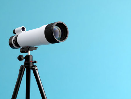 Telescope on tripod against blue backgroundの素材