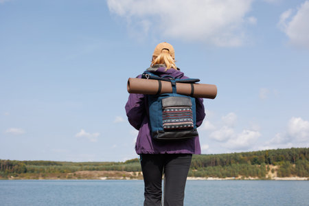 Rear view of female hiker with backpack by lake