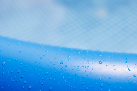 Water drops on blue inflatable pool rim close-up macro viewの写真素材
