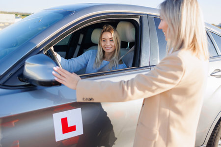 Driving Instructor Checking Exterior Mirrors of Learner Vehicle Before Testの写真素材