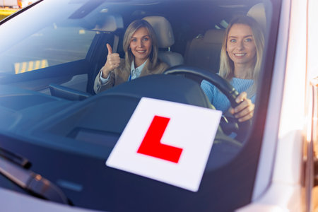 Learner Driver with Instructor Showing Thumbs Up in Vehicleの写真素材