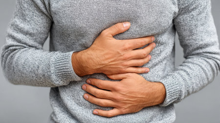 Man holding stomach in discomfortの素材