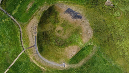 Aerial view of a green meadow with a path winding through itの写真素材