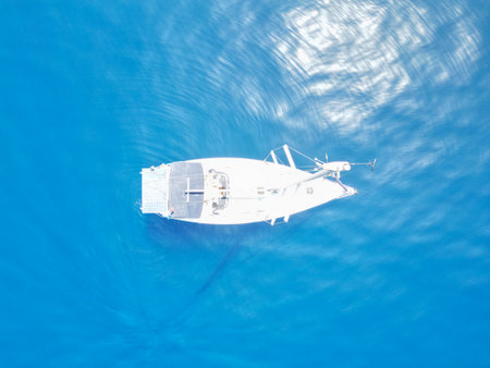 Aerial view of a boat in the blue sea with reflection in waterの写真素材