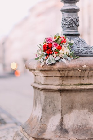 Beautiful  wedding bouquet with red roses and pink peonies on the vintage baroque lanternの写真素材