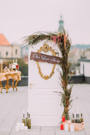 White door decorated with cute wedding stuff and  flowers on the rooftop.の写真素材