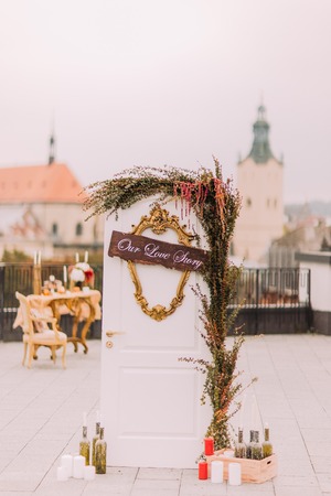 White vintage door decorated with flowers and candles as symbol of wedding love story.の写真素材