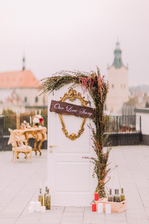 White vintage door on the rooftop decorated with green and flowers. Wedding day.の写真素材