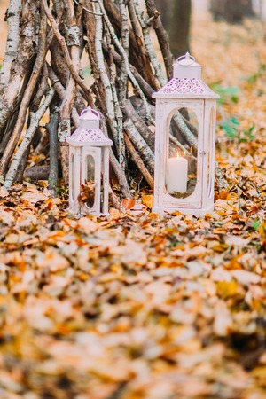 White vintage candle lanterns in the autumn woods.の写真素材