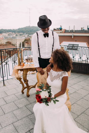 Beatuful newlyweds lovingly look at each other on the rooftop.の写真素材